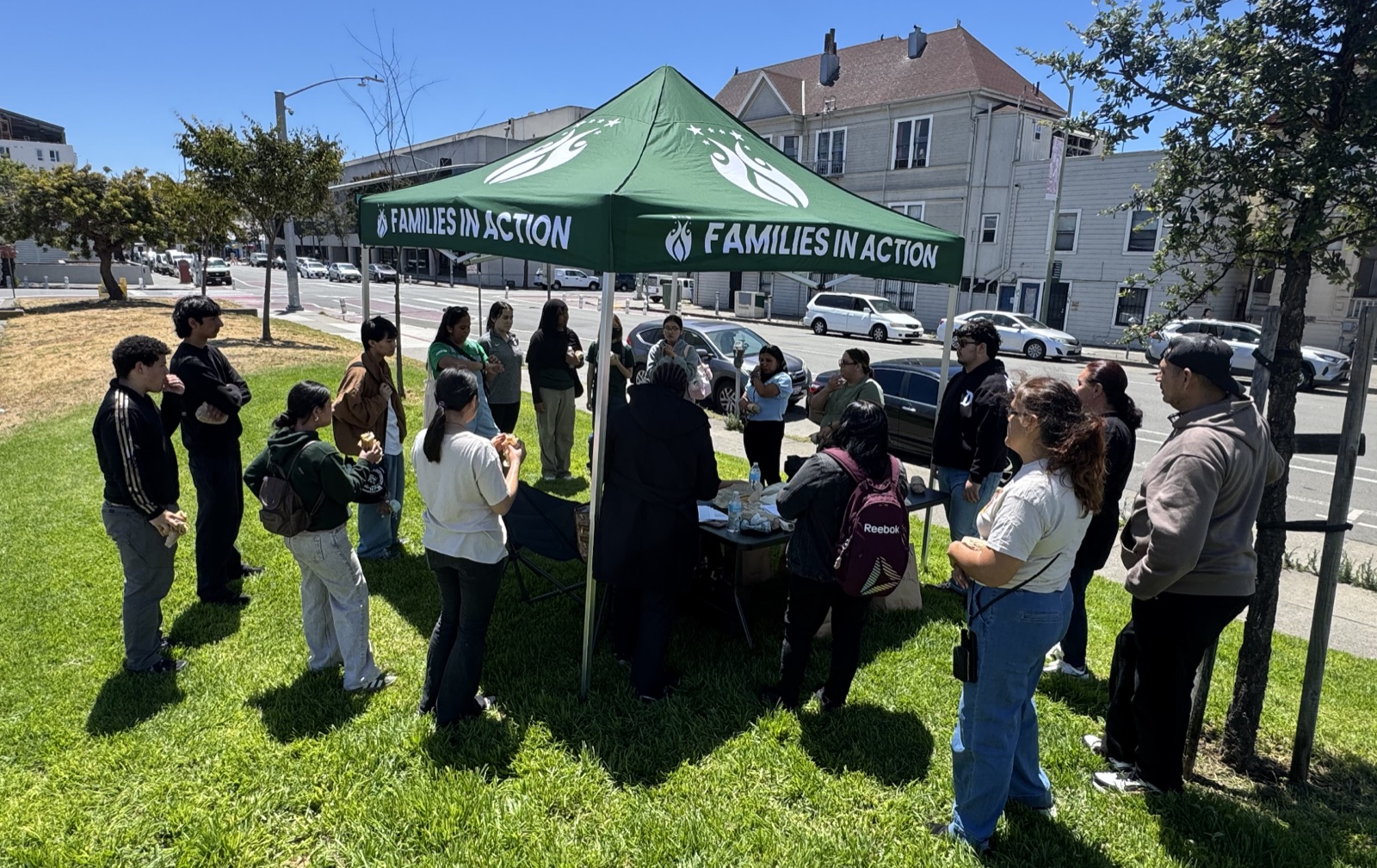 Leaders gathered under a Families in Action tent during community outreach