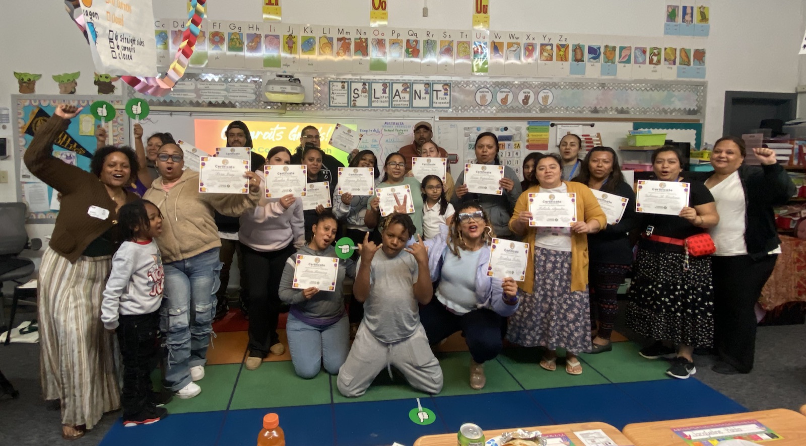 Parent leaders holding graduation certificates in a classroom at the end of Lit for Literacy