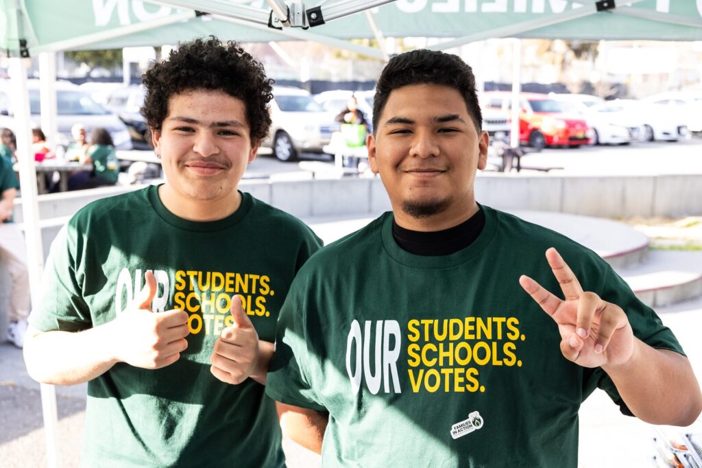 Two students with shirts that say Our Students Schools votes