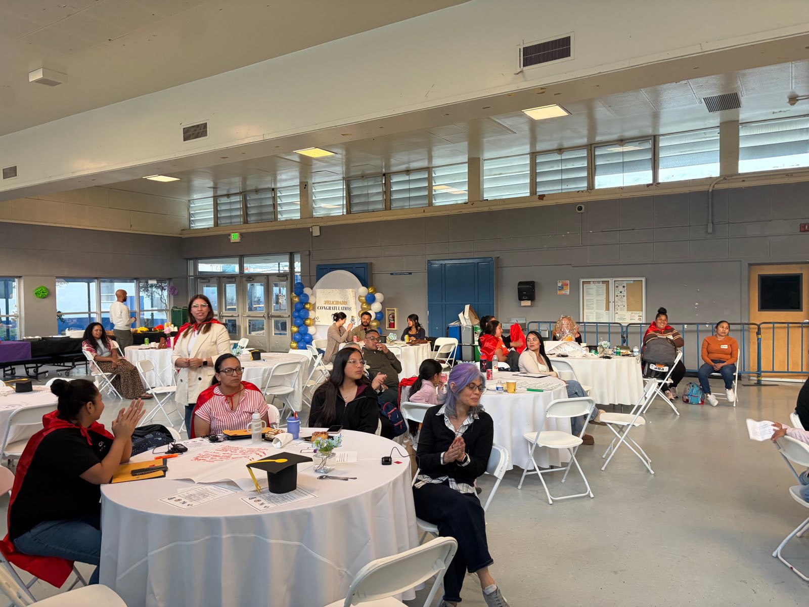 Families seated at tables during the Promise Champions graduation celebration